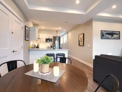 a dining room and living room with a table and a couch at Oceanfront Relaxing & Stunning View - Pet Friendly in Port Renfrew