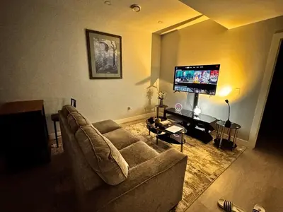 a living room with a couch and a flat screen tv at Private 1BR Basement Suite in NE Calgary in Calgary