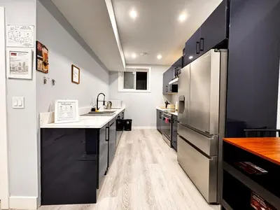 a kitchen with a sink and a refrigerator at Private 1BR Basement Suite in NE Calgary in Calgary