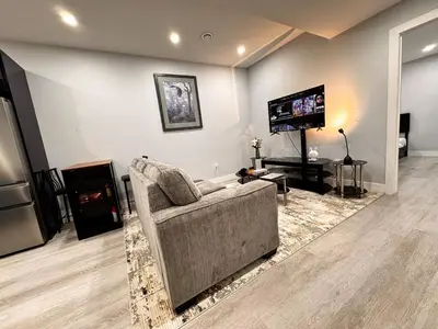 a living room with a couch and a television at Private 1BR Basement Suite in NE Calgary in Calgary