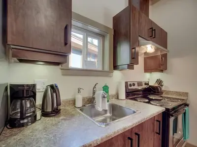 a kitchen with a sink and a stove at A slice of paradise with Hot Tub - Pet Friendly in Port Renfrew