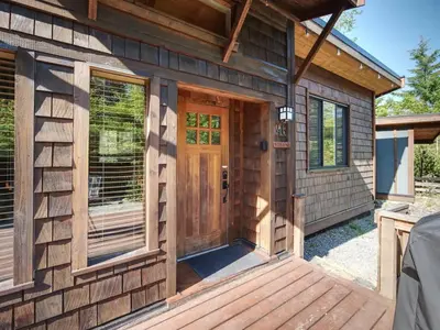 a wooden front door of a tiny house at A slice of paradise with Hot Tub - Pet Friendly in Port Renfrew