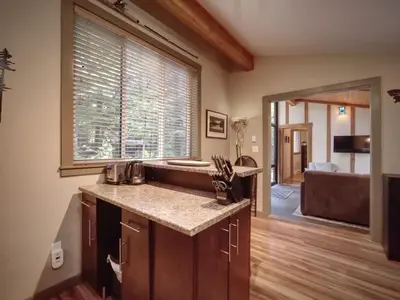 a kitchen with a sink and a large window at Private treed setting - no pets - garden view in Port Renfrew