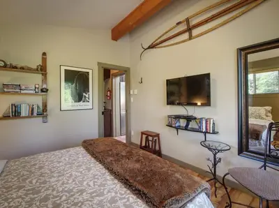 a bedroom with a bed and a flat screen tv at Quiet Romantic Getaway - Non Pet Friendly in Port Renfrew