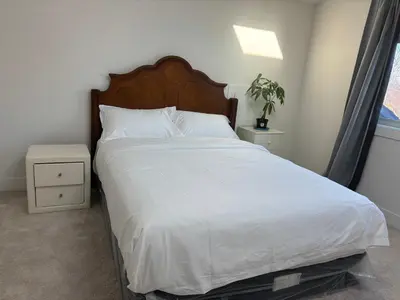 a bedroom with a large bed with white sheets at Comfortable Private Room in a Shared Home in Richmond