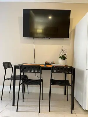 a black table with chairs and a television on a wall at Chic suite close to UBC in Vancouver