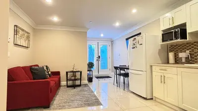 a living room with a red couch and a kitchen at Chic suite close to UBC in Vancouver
