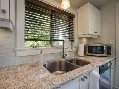 a kitchen with a sink and a microwave at Oceanfront view 2 entertainment areas -Pet Friendly in Port Renfrew