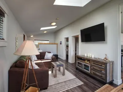a living room with a couch and a flat screen tv at Oceanfront view 2 entertainment areas -Pet Friendly in Port Renfrew