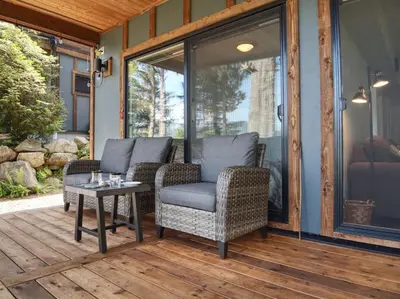 a screened porch with two chairs and a table at Oceanfront view 2 entertainment areas -Pet Friendly in Port Renfrew