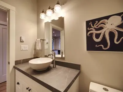 a bathroom with a sink and an octopus painting on the wall at The Salty Dog - Oceanfront Getaway - Great View - Pet Friendly in Port Renfrew
