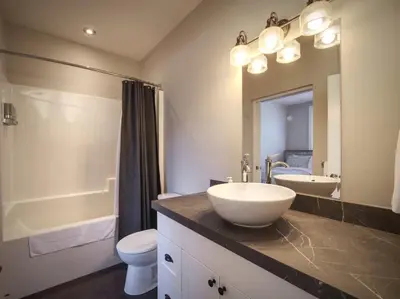 a bathroom with a sink and a toilet and a mirror at Oceanfront & Amazing Views - Pet Friendly - 2bdrm in Port Renfrew