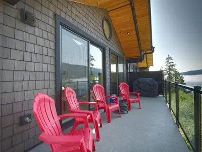 a group of pink chairs and tables on a porch at Oceanfront & Amazing Views - Pet Friendly - 2bdrm in Port Renfrew
