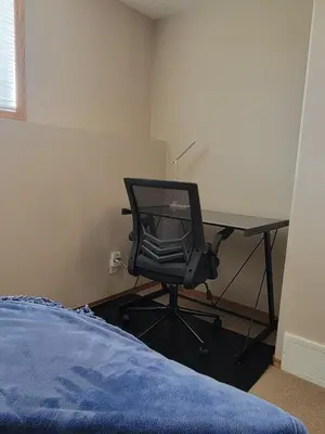 a bedroom with a desk with a chair and a bed at Quaint Lonsdale Suite in Red Deer