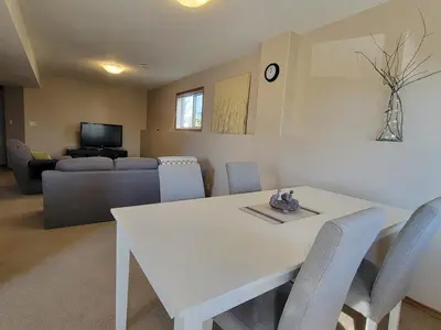 a living room with a white table and chairs at Quaint Lonsdale Suite in Red Deer