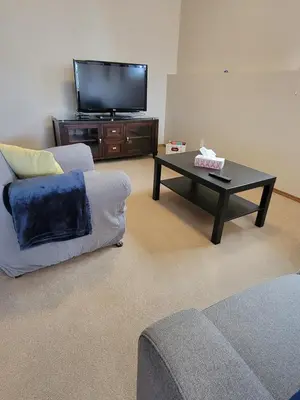 a living room with a tv and a coffee table at Quaint Lonsdale Suite in Red Deer