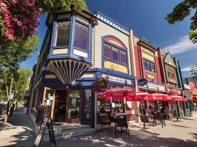 a building on a city street with tables and chairs at Private ensuite bedroom with independent entrance in South Pandosy Gyro beach OC KGH in Kelowna