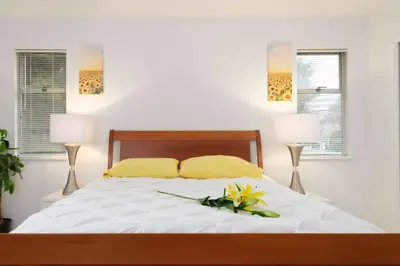 a bedroom with a bed with yellow pillows and two lamps at Private Room with Full Amenities in Cozy House in Vancouver