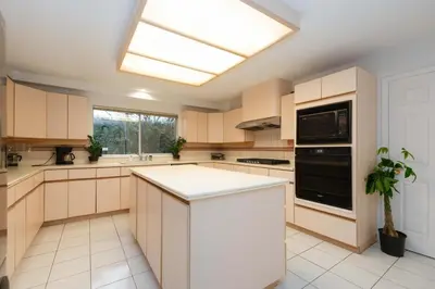 a large kitchen with white cabinets and a skylight at Private Room with Full Amenities in Cozy House in Vancouver
