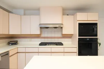 a kitchen with white cabinets and a stove top oven at Private Room with Full Amenities in Cozy House in Vancouver