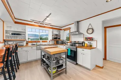 a kitchen with white cabinets and a stove top oven at Hot tub - Sauna - Panoramic Ocean View THE POINT - Pet Friendly in Port Renfrew