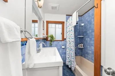 a bathroom with a white sink and blue tiles at Hot tub - Sauna - Panoramic Ocean View THE POINT - Pet Friendly in Port Renfrew