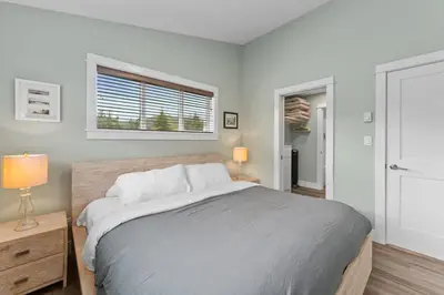 a bedroom with a large bed and a window at Oceanview - Pet Friendly - Gas Fireplace - Wild Beauty in Port Renfrew