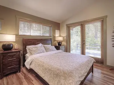 a bedroom with a large bed and two windows at Explorers Retreat Private Sauna - Pet Friendly in Port Renfrew
