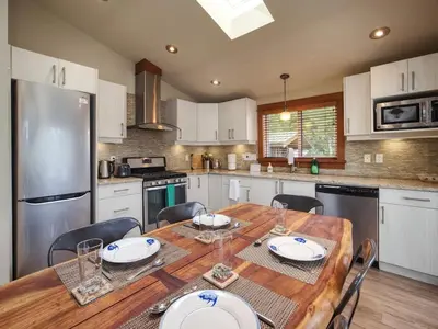 a kitchen with a wooden table with chairs around it at Going Coastal A - Oceanfront - Pet Friendly in Port Renfrew