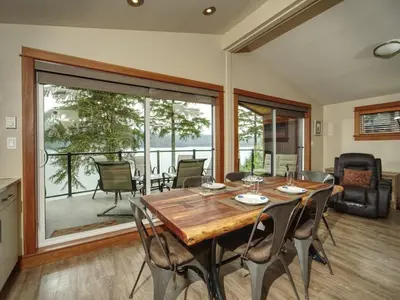 a dining room with a wooden table and chairs at Going Coastal A - Oceanfront - Pet Friendly in Port Renfrew