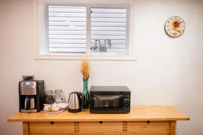 a table with a microwave and a coffee maker on it at Spacious 2-Bedroom Basement Suite in Whitehorn, Close to Calgary Airport, Hospital, & Train in Calgary