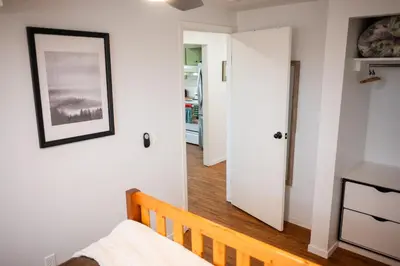 a bedroom with a bed and a door to a hallway at Spacious 2-Bedroom Basement Suite in Whitehorn, Close to Calgary Airport, Hospital, & Train in Calgary