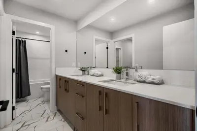 a bathroom with two sinks and a large mirror at Family Condo w Kids Den FREE Banff Pass in Calgary