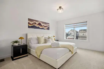 a white bedroom with a large bed and a window at NEW Family 3BR Upper Suite w Kid's Play Den, Free Banff Pass in Calgary