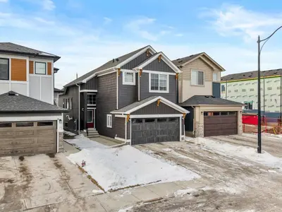 a house with two garage doors in a driveway at NEW Family 3BR Upper Suite w Kid's Play Den, Free Banff Pass in Calgary