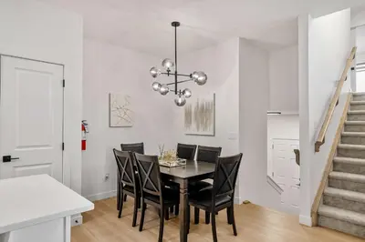 a dining room with a black table and chairs at NEW Family 3BR Upper Suite w Kid's Play Den, Free Banff Pass in Calgary