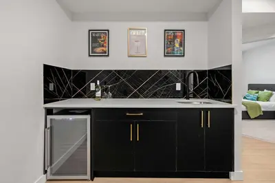 a kitchen with black cabinets and a counter top at Large 5BR Family Home w Kids Play Den & Private Basement Suite Included, FREE Banff Pass! in Calgary