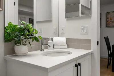 a bathroom with a sink and a potted plant at Large 5BR Family Home w Kids Play Den & Private Basement Suite Included, FREE Banff Pass! in Calgary