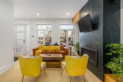 a living room with yellow chairs and a couch at Trendy Bridgeland, Fireplace, King Beds, AC in Calgary