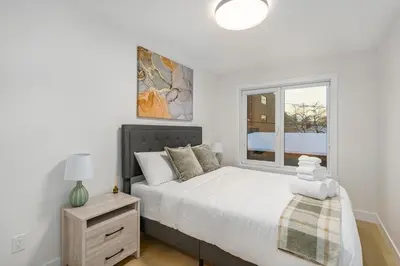 a bedroom with a large bed and a window at Trendy Bridgeland, Fireplace, King Beds, AC in Calgary