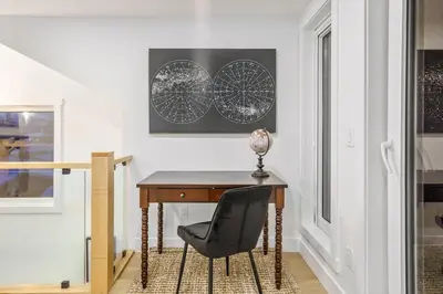 a desk with a chair next to a window at Trendy Bridgeland, Fireplace, King Beds, AC in Calgary