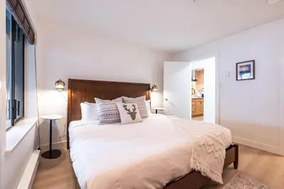 a bedroom with a large bed with white sheets and pillows at Wintergreen 26 by Outpost Whistler in Whistler