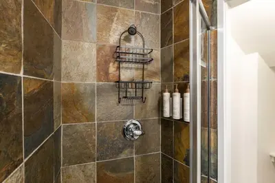 a bathroom with a shower with a tiled wall at Wintergreen 26 by Outpost Whistler in Whistler