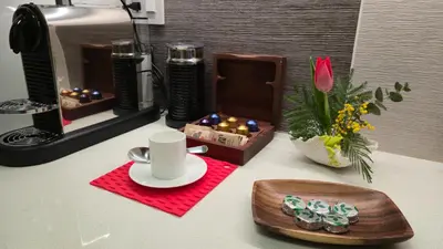 a table with a cup of coffee and a vase with flowers at Modern Coastal 2BR Retreat with Private Hot Tub in Vancouver BC in West Vancouver