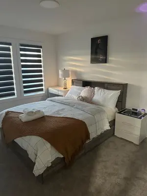 a bedroom with a large bed with two towels on it at Brand New 3 Bedroom house SW Edmonton in Edmonton