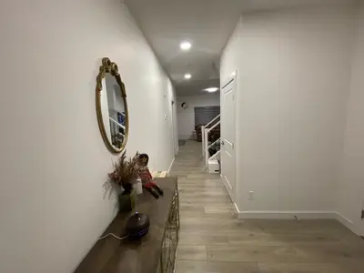 a child sitting on the floor in a hallway with a mirror at Brand New 3 Bedroom house SW Edmonton in Edmonton