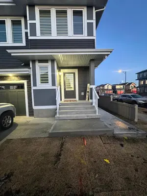 a house with a driveway and stairs in front of it at Brand New 3 Bedroom house SW Edmonton in Edmonton