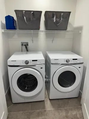 a laundry room with a washing machine and a washer at Brand New 3 Bedroom house SW Edmonton in Edmonton