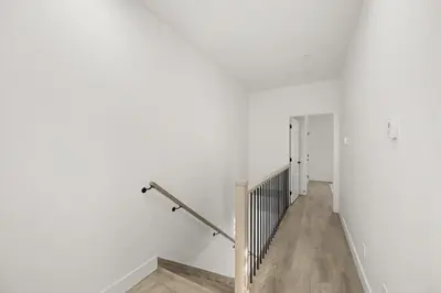 an empty hallway with white walls and wooden floors at Bright Modern 3 Bedroom Suite in Vancouver in Vancouver
