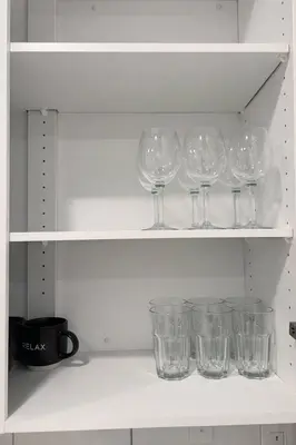 a row of wine glasses sitting on a shelf at Condo w 2 Beds 13 Mins from West Edmonton Mall in Edmonton